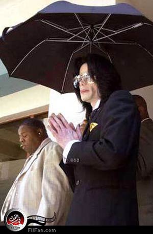 مايكل جاكسون في حماية حراسه الشخصيين أثناء مغادرته مبنى المحكمة بمقاطعة سانتا باربرا يوم الأربعاء- الصورة من رويترز