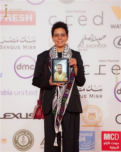 المخرجة مي سعد تحمل صورة زميلها المحاصر في غزة ... وتصفيق حار لفيلم ضايل عنا عرض بمهرجان القاهرة السينمائي
