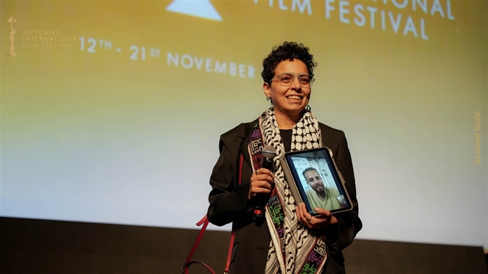المخرجة مي سعد تحمل صورة زميلها المحاصر في غزة ... وتصفيق حار لفيلم ضايل عنا عرض بمهرجان القاهرة السينمائي