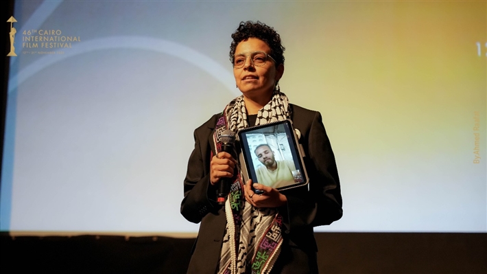 المخرجة مي سعد تحمل صورة زميلها المحاصر في غزة ... وتصفيق حار لفيلم ضايل عنا عرض بمهرجان القاهرة السينمائي