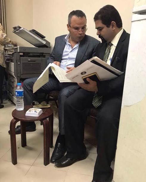 تامر عبد المنعم ينظر في أوراق الدعوة مع محاميه قبل الجلسة
