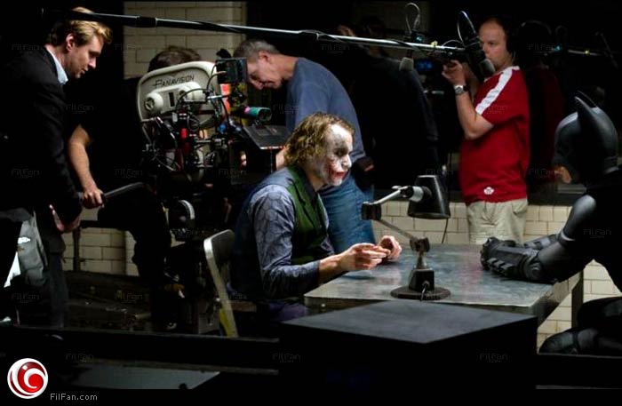 المخرج كريستوفر نولان يقف خلف هيث ليدجر وكريستيان بيل أثناء التحضير لمشهد الاستجواب في فيلم The Dark Knight