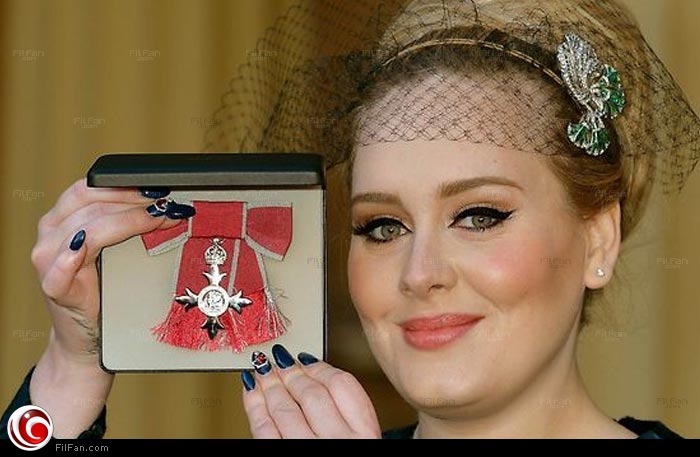 أديل أثناء تسلمها رتبة الإمبراطورية البريطانية من الأمير تشارلز