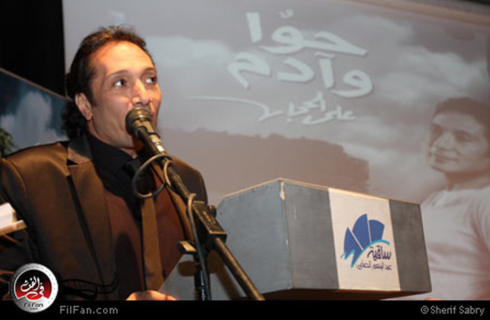 علي الحجار وفي الخلفية الملصق الدعائي لألبوم "حوا وآدم"