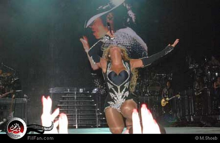 بيونسيه على ركبتيها وخلفها صورة الملك مايكل جاكسون