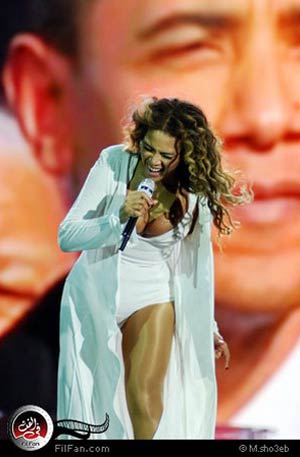 بيونسيه ترتدي روبا أبيض، وفي الخلفية صورة الرئيس الأمريكي باراك أوباما&lt;br&gt;
تصوير: محمد شعيب