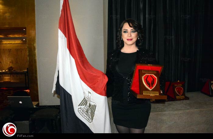 سلاف فواخرجي ممسكة بعلم مصر بعد تكريمها من الجمعية الخيرية لمساعدة المسنين