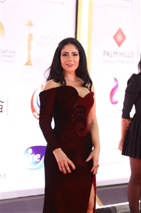 منى زكي بفستان مخملي أنيق مناسب للأجواء الشتوية، واللون البرجندي أنيق هذا الموسم