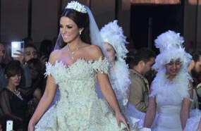 كان "مسك ختام" عرض أزياء هاني البحيري إطلالة درة بفستان زفاف أبيض بسيط التصميم