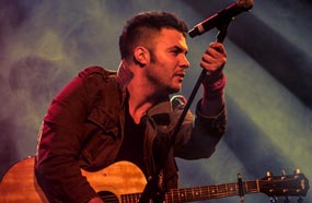 أمير عيد حاملا جيتاره الشهير