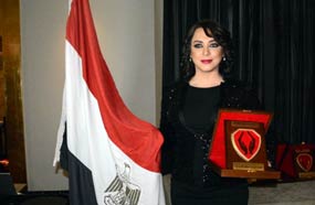 سلاف فواخرجي ممسكة بعلم مصر بعد تكريمها من الجمعية الخيرية لمساعدة المسنين